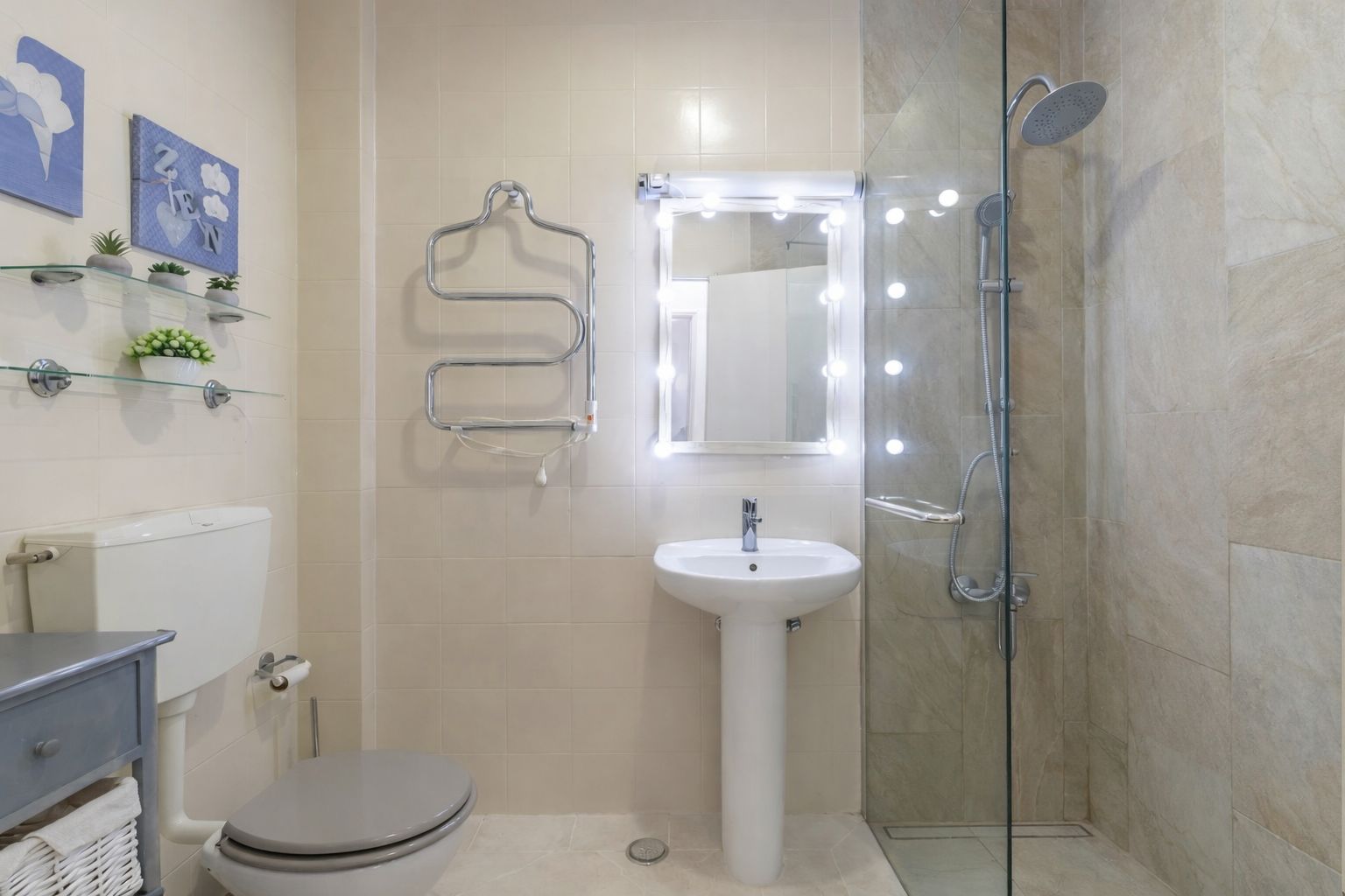 Bathroom with walk-in shower, clean tiling, and fresh towels folded on a wooden shelf