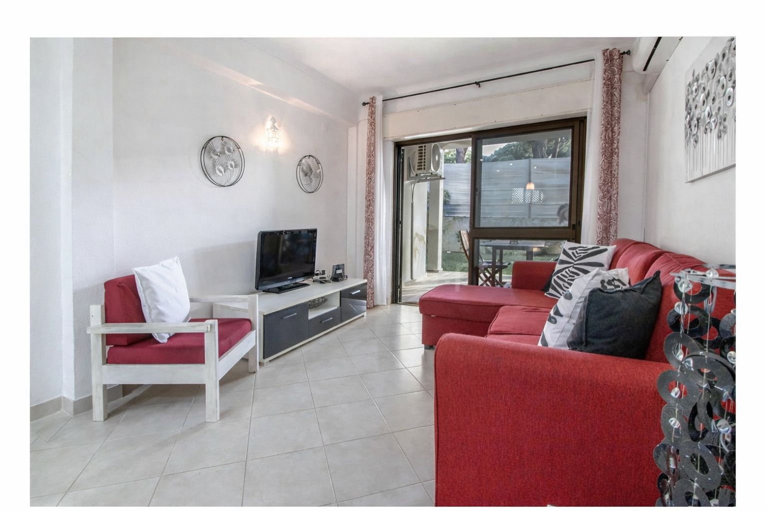 Second bedroom with a double bed, soft pastel linens, and a bright window