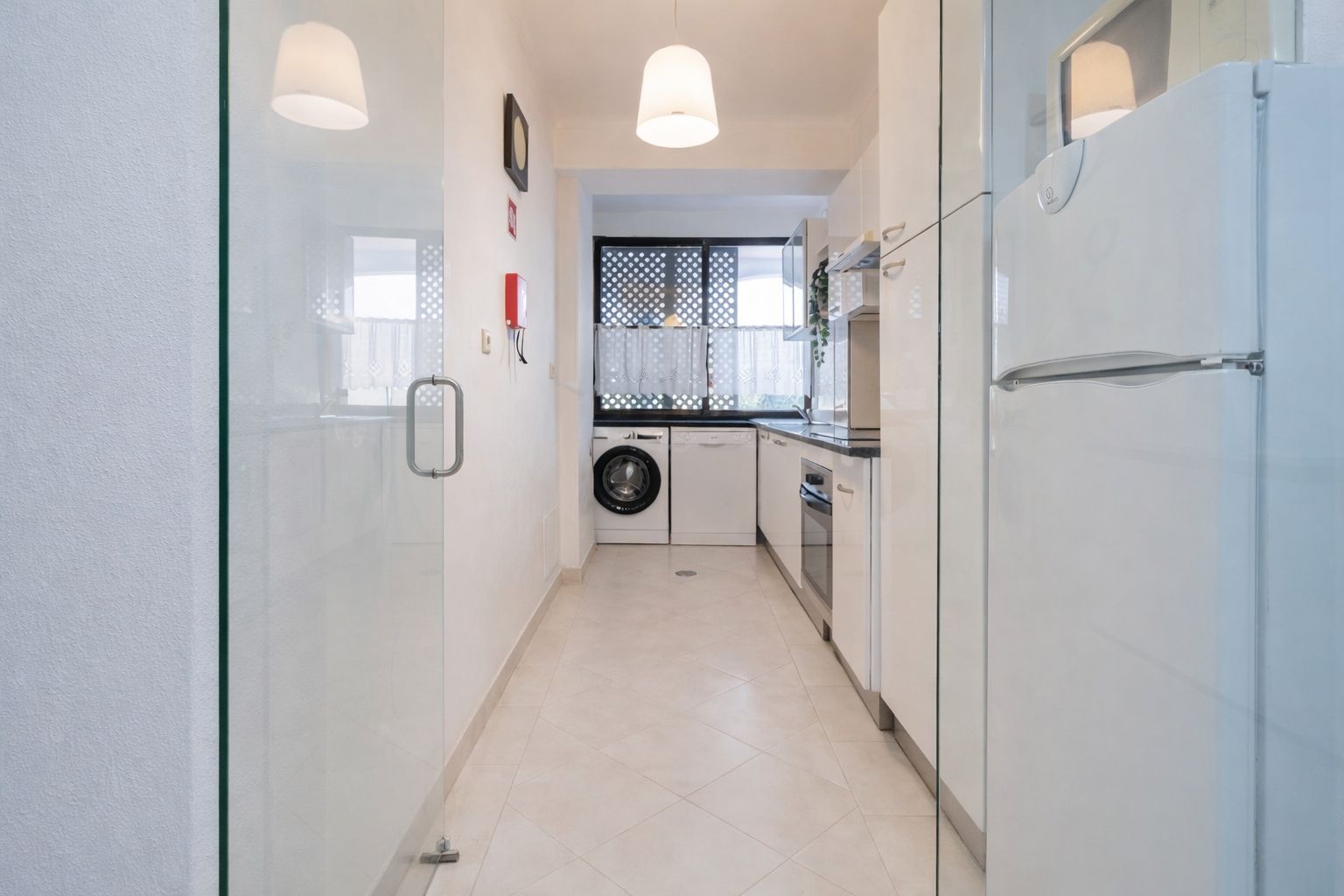 Kitchen view from the dining area, with full appliances and a light-filled window