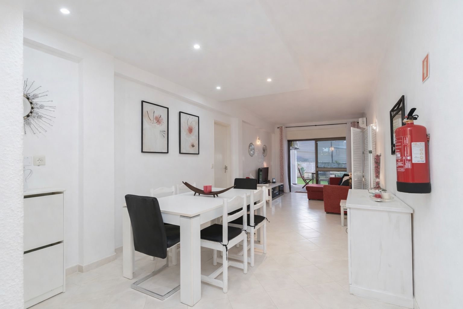 Living room with a light linen sofa, soft cushions, and an open doorway to the patio