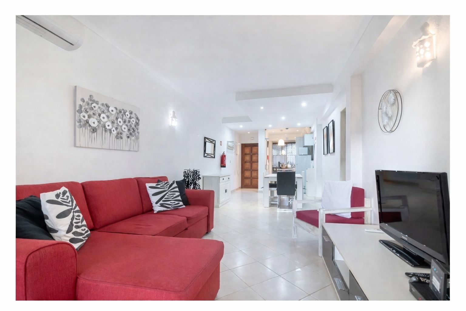 Living room seen from the dining corner, with natural light flooding in