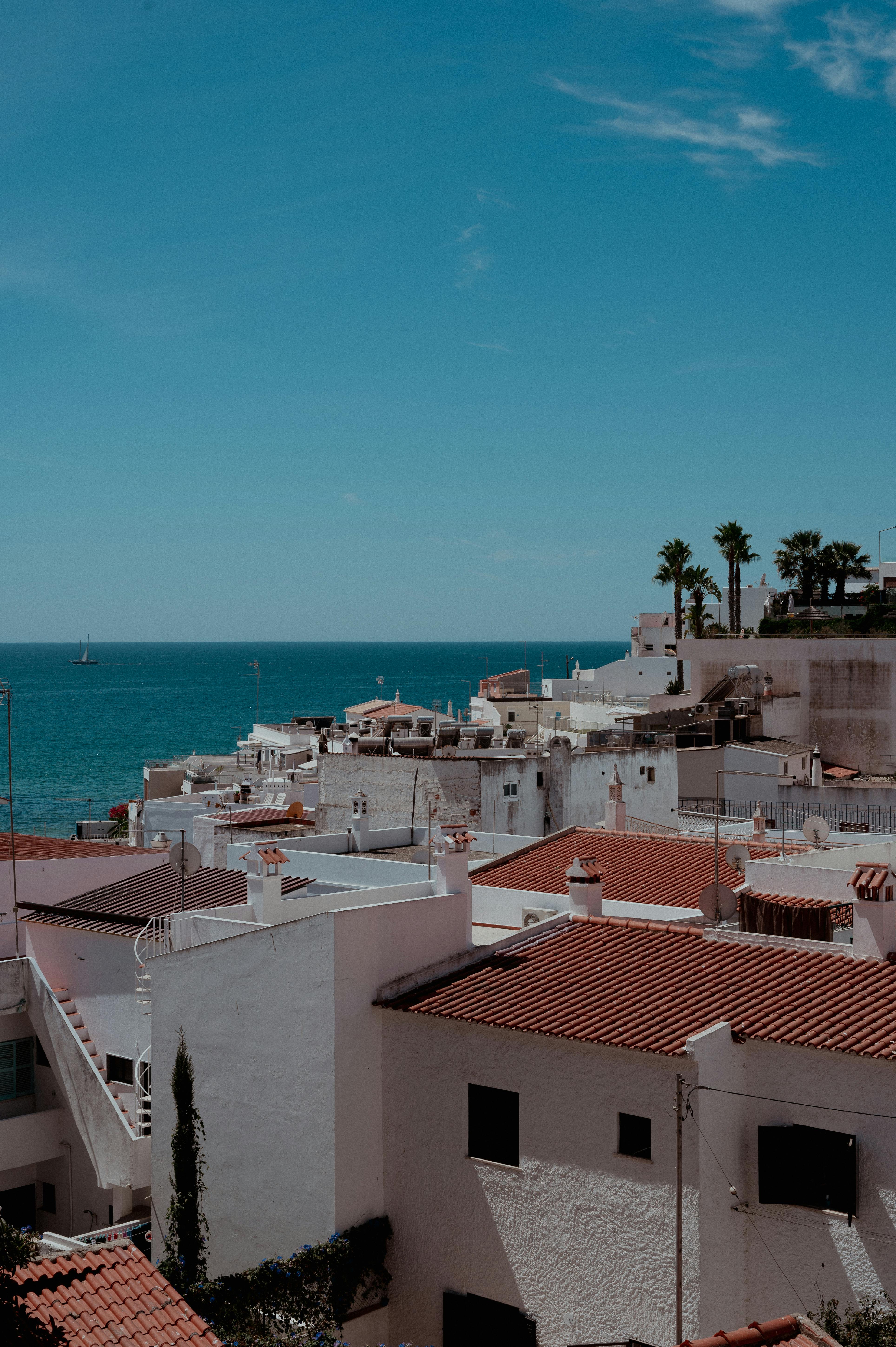 Whitewashed Algarve village rooftops leading down to the sea